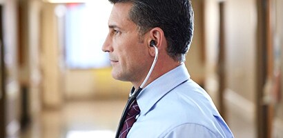 Arzt trägt sein Littmann Stethoskop korrekt, mit nach vorne zeigenden Ohroliven.
