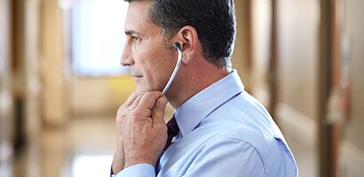 Arzt setzt ein Littmann Stethoskop korrekt, mit nach vorne zeigenden Ohroliven, auf.
