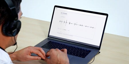 Arzt, der einen Laptop benutzt und sich das Live-Video der telemedizinischen Auskultation
