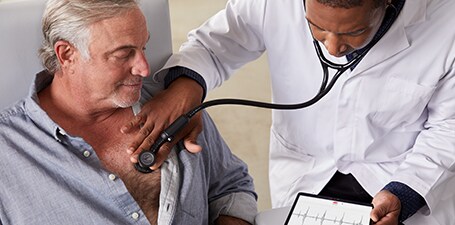 Arzt, der das 3M Littmann CORE Digital-Stethoskop auf den Brustkorb eines Mannes drückt
