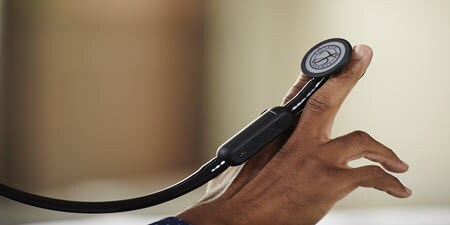 Nahaufnahme eines Littmann CORE Digital-Stethoskops, das auf den Fingern einer Person ruht.

