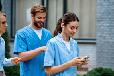 Weibliche Medizinstudentin schaut auf ein Smartphone.
